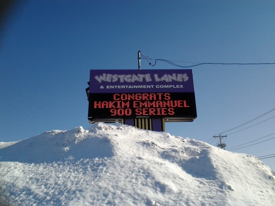 The outdoor sign congratulating Hakim Emmanuel on his 900 series. The pile of snow in the foreground adds to the effect, giving the impression that he conquered the historic bad weather at the time to bowl it.